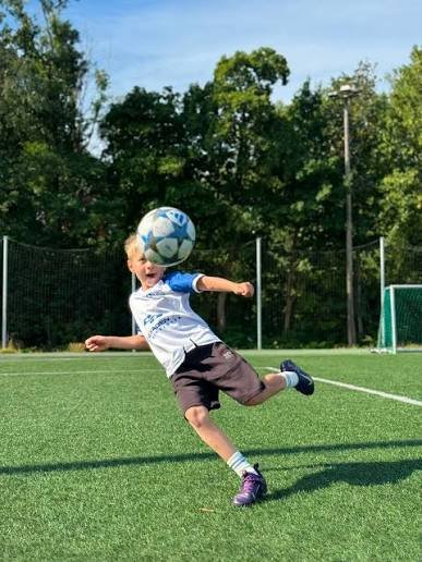 Ung spiller skyter på ballen under trening